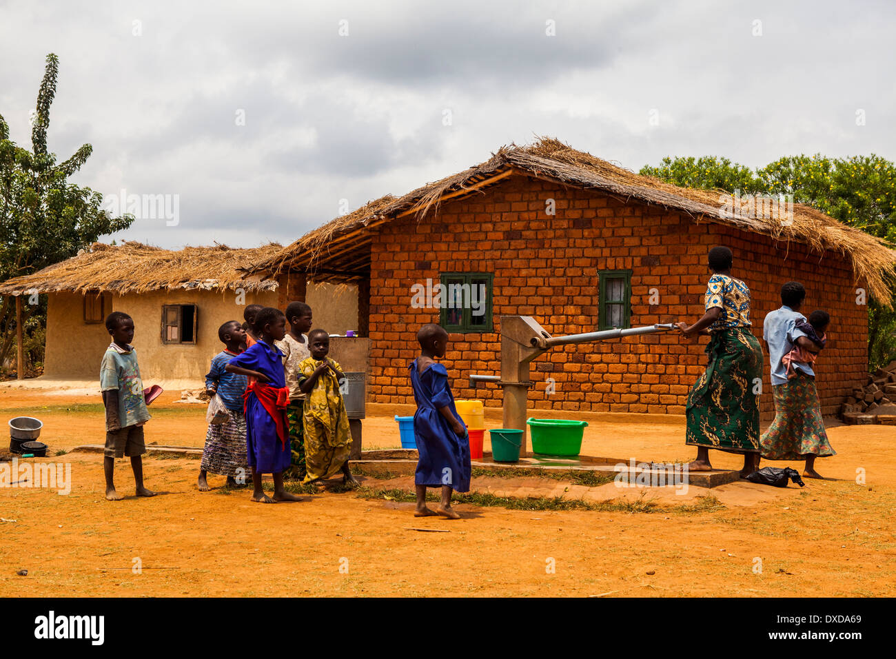 Los aldeanos africanos recoger agua en una bomba de agua comunales Foto de stock