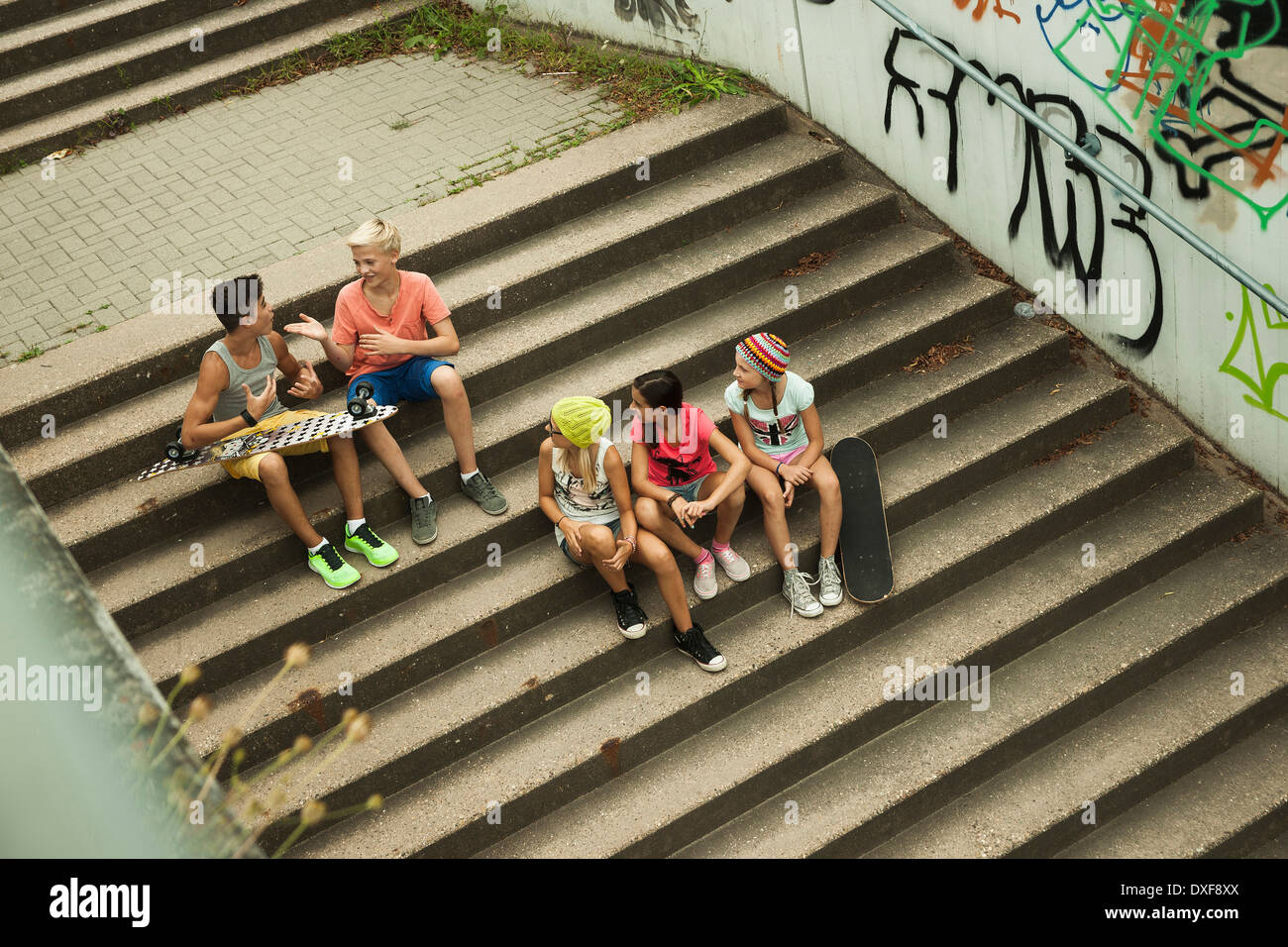 Vista aérea del grupo de niños sentados en las escaleras exteriores, Alemania Foto de stock