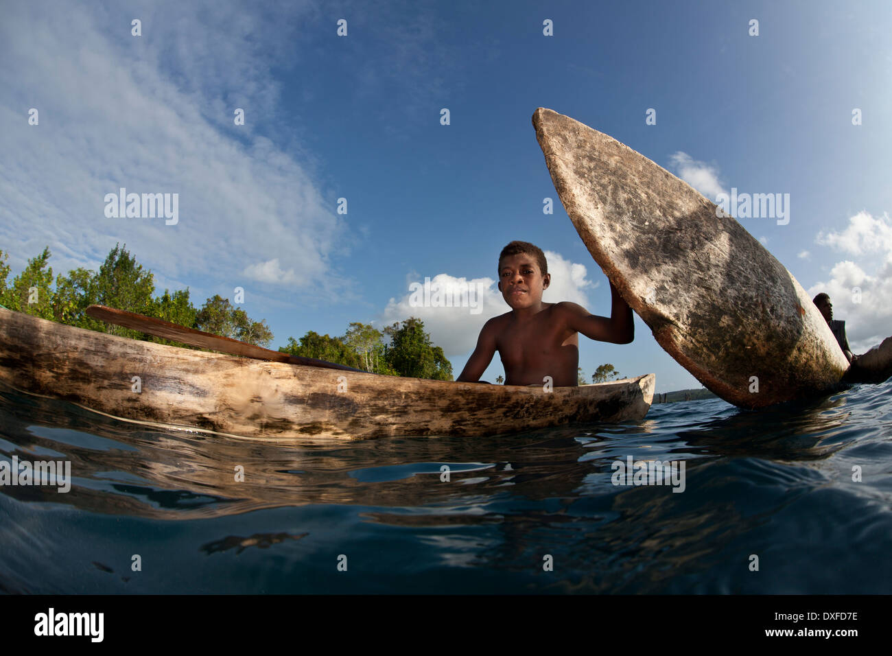 Palas muchacho su canoa, Melanesia, el Océano Pacífico, las Islas Salomón Foto de stock