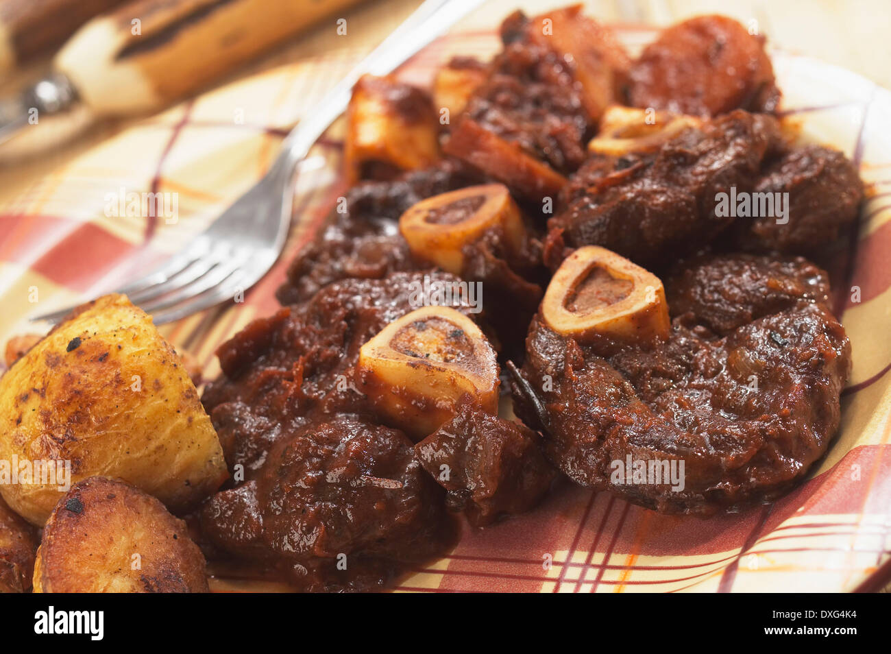 Plato de Ossobucco servido con patatas asadas Foto de stock