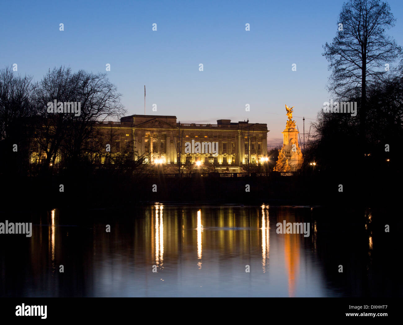 El Palacio de Buckingham y el Victoria Memorial se refleja en el lago en St James's Park en la noche Londres England Reino Unido Foto de stock