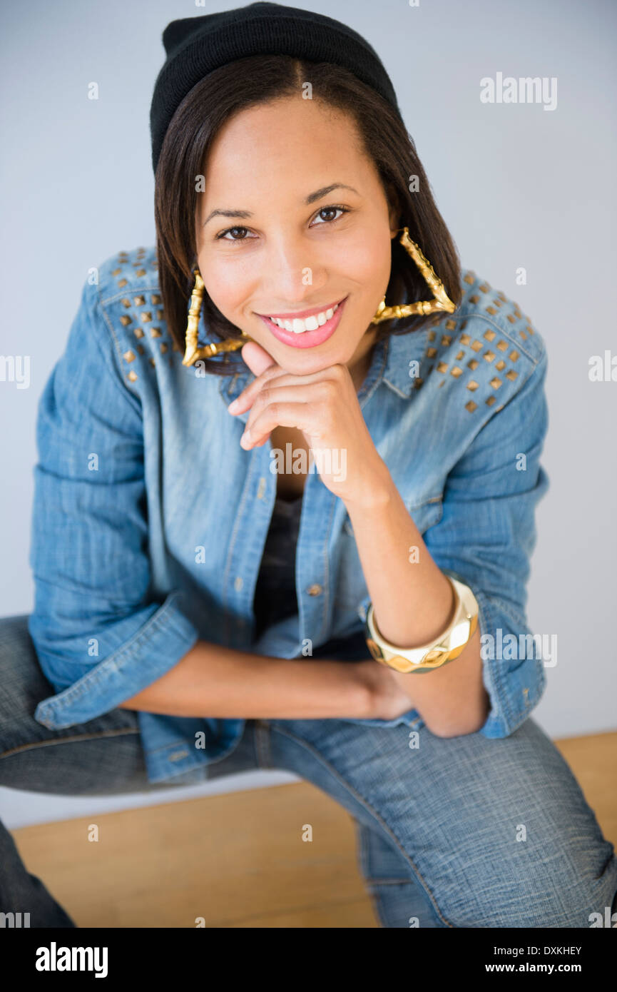 Retrato de mujer de raza mixta sonriente con la mano en la barbilla Foto de stock
