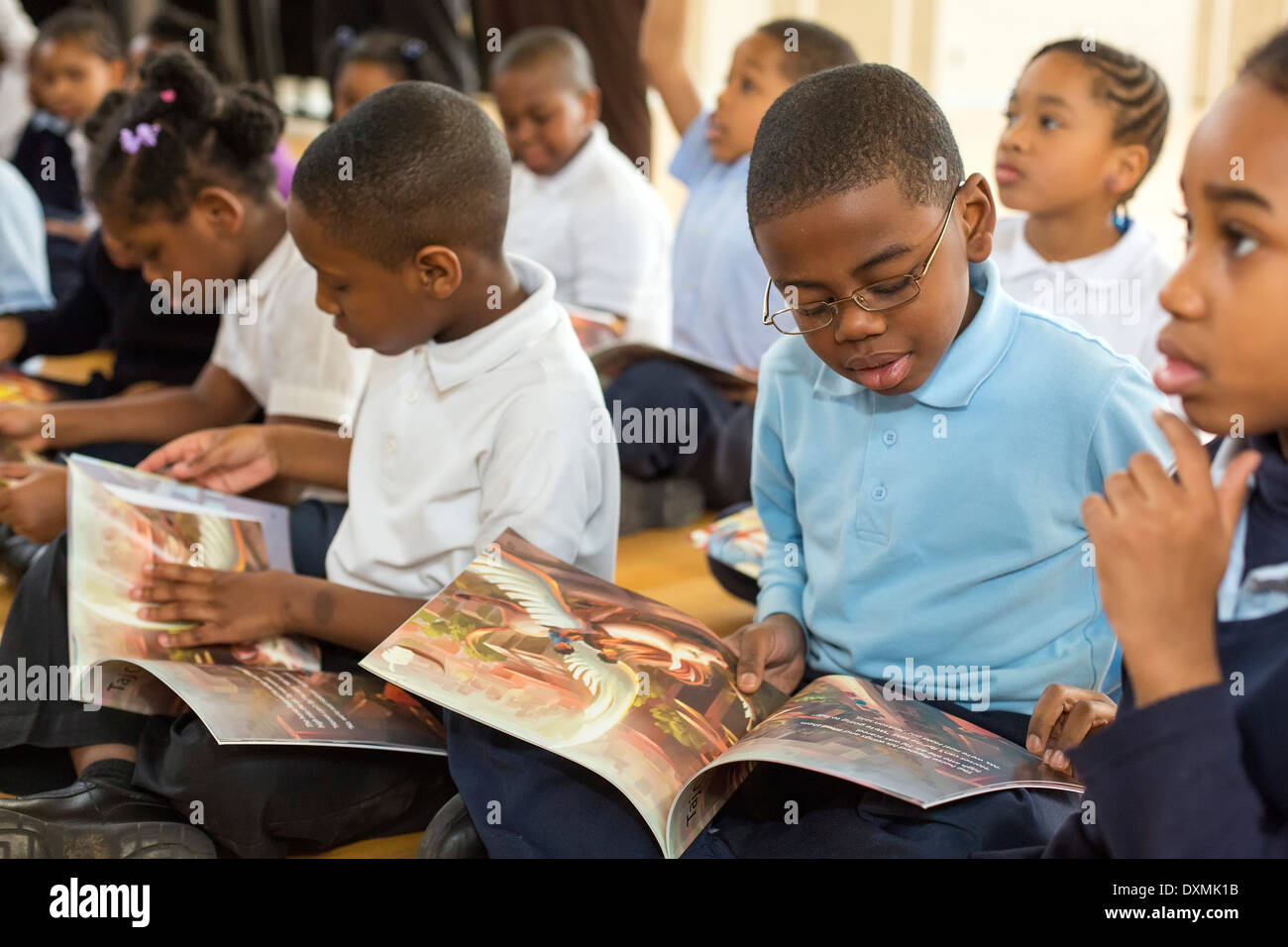Los estudiantes de kindergarten y primer grado en la escuela primaria de Chrysler en Detroit, leer un libro. Foto de stock