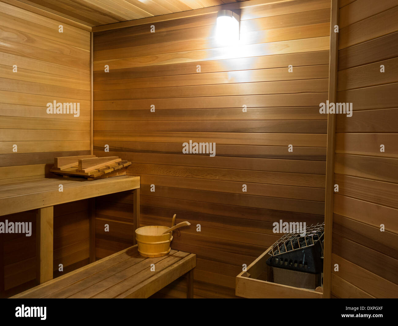 Sauna forrado de cedro con calefactor, cubo de agua y sentarse estantes, EE.UU. Foto de stock