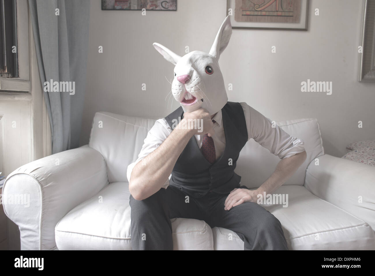 Máscara de conejo hombre sentado en el sofá en casa Fotografía de stock -  Alamy