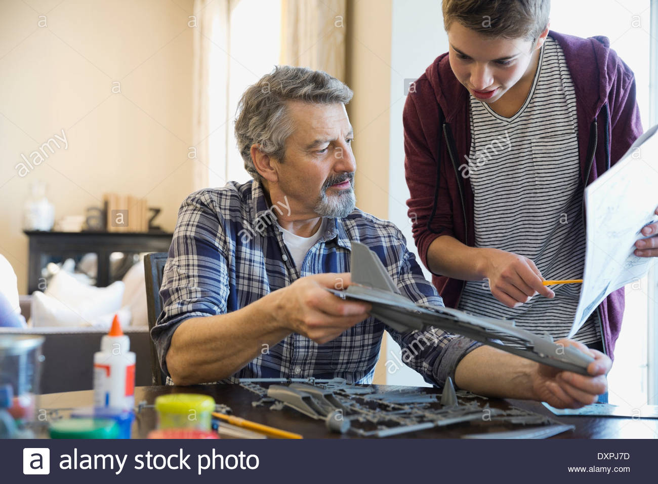 Abuelo y nieto de construcción de modelo de avión en casa Foto de stock