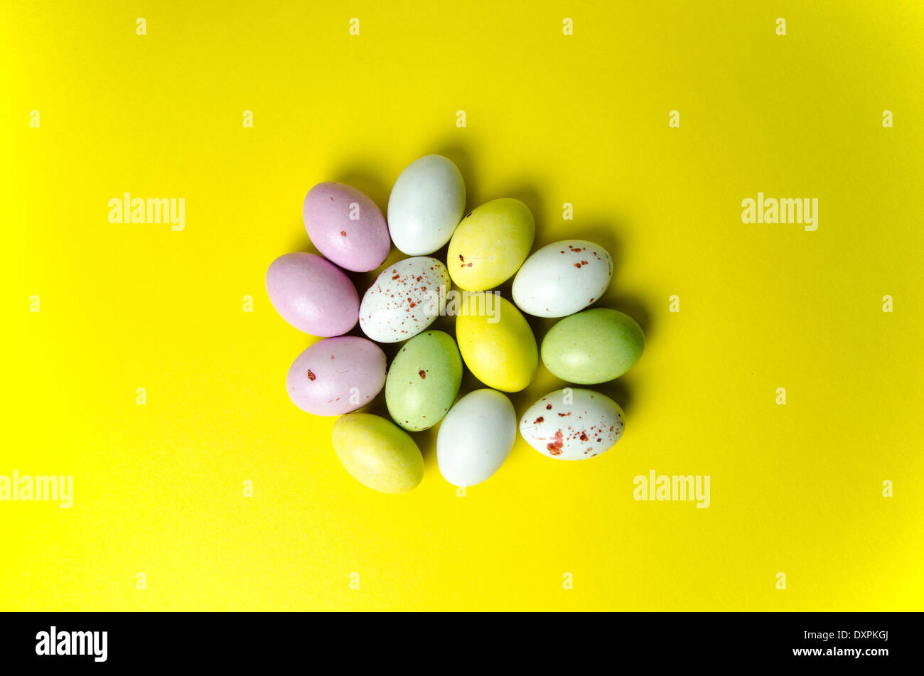 Huevos de pascua multicolores confección en fondo amarillo Foto de stock