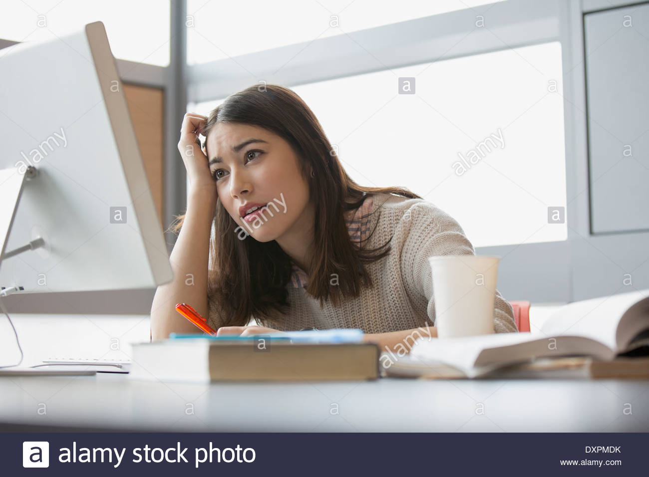 Frustrado estudiante universitario estudiando en equipo Foto de stock