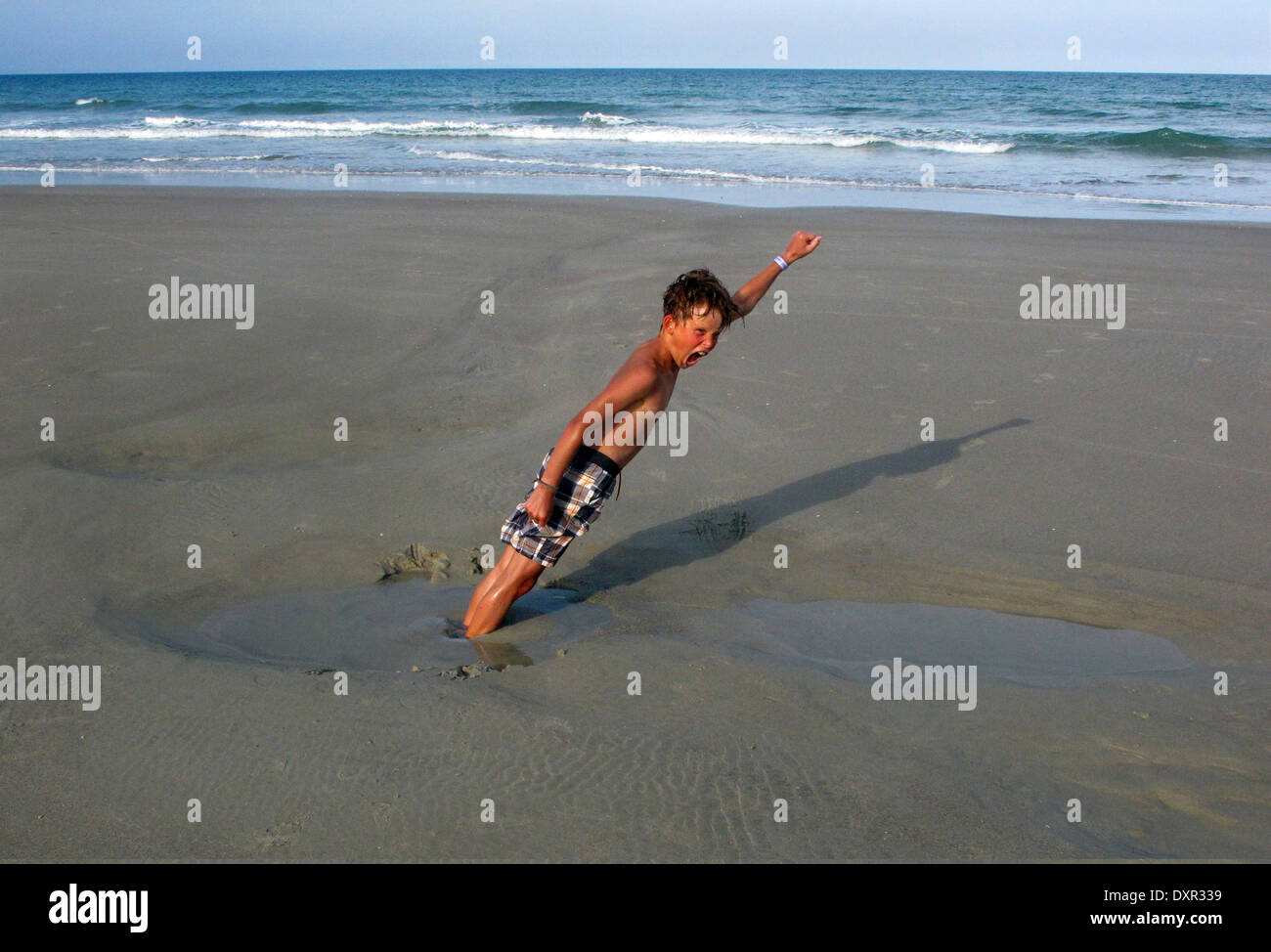 Cocoa Beach, Florida, boy enchufado firmemente en la arena de la playa Foto de stock