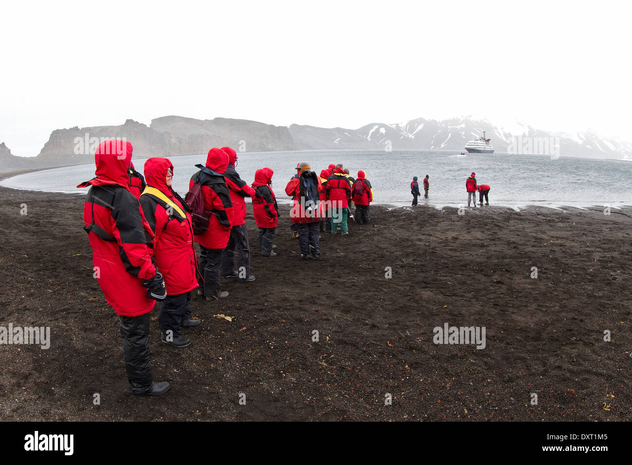 Los pasajeros de los cruceros a la antártida dejando Caleta Balleneros, Isla Decepción por el zodíaco. Turismo antártico. Las Islas Shetland del Sur. Foto de stock