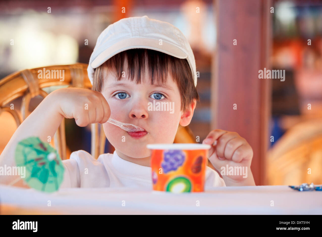 Cute little boy comer helado en la cafetería interior Foto de stock