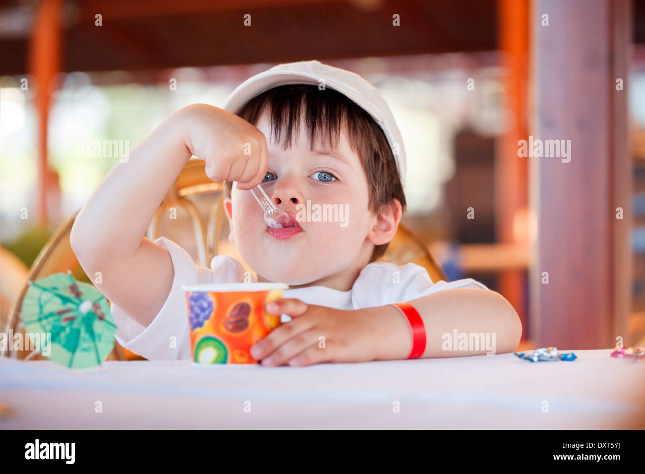 Cute little boy comer helado en la cafetería interior Foto de stock