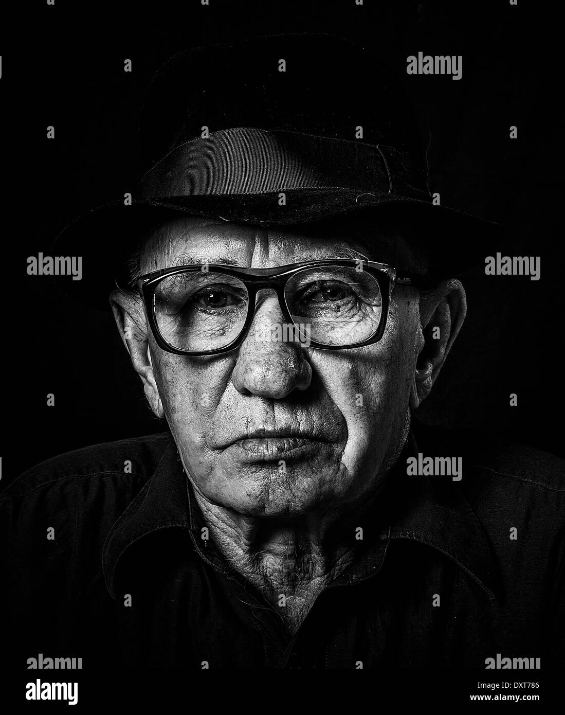 Retrato artístico de un hombre viejo con gafas y sombrero Foto de stock