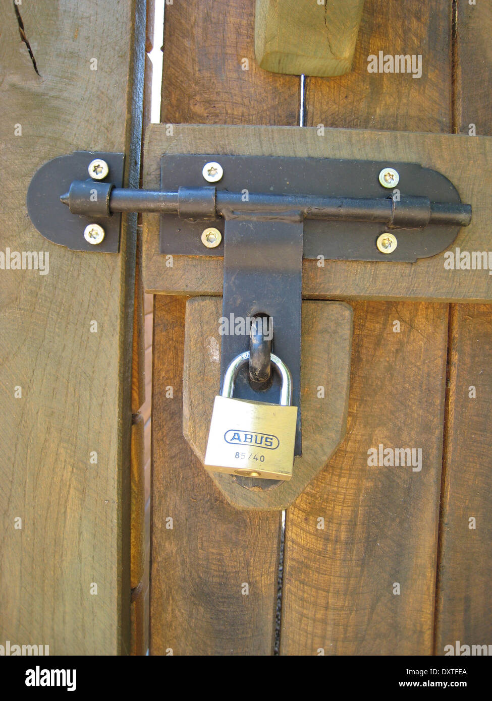 Una cerradura con pestillo en la puerta de madera Foto de stock