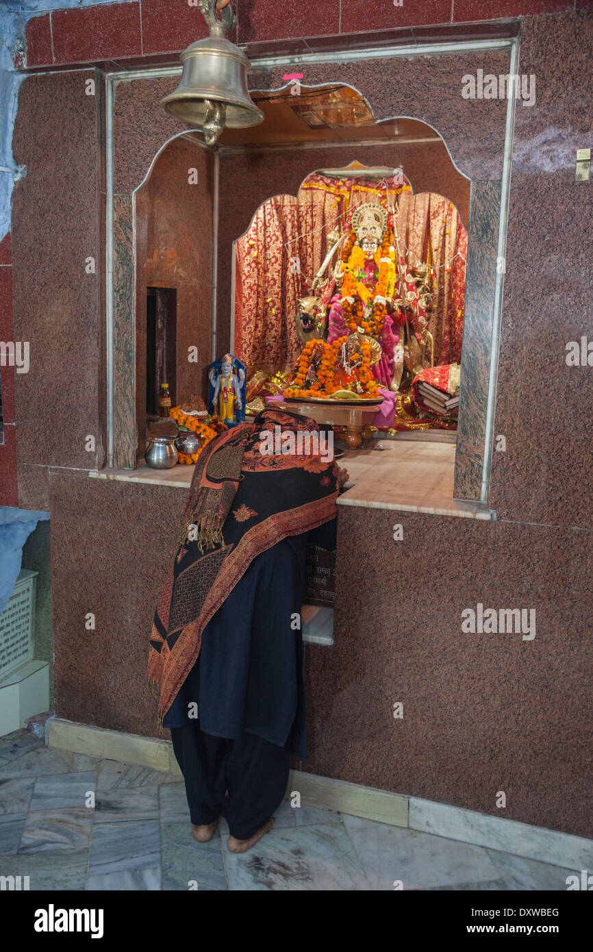 Dehradun, India. Mujer rezando en el Santuario de la diosa Durga Maa, montando un tigre, armados para destruir a los demonios. Foto de stock