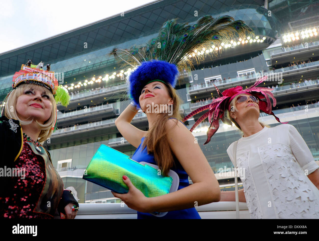 Tres damas de moda en la Copa del Mundo de Dubai campeonato de carreras de caballos en el hipódromo de Meydan, en Dubai, Emiratos Árabes Unidos Foto de stock