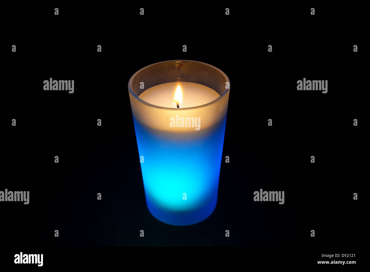 Luz quemando velas azul aislado sobre fondo negro Foto de stock