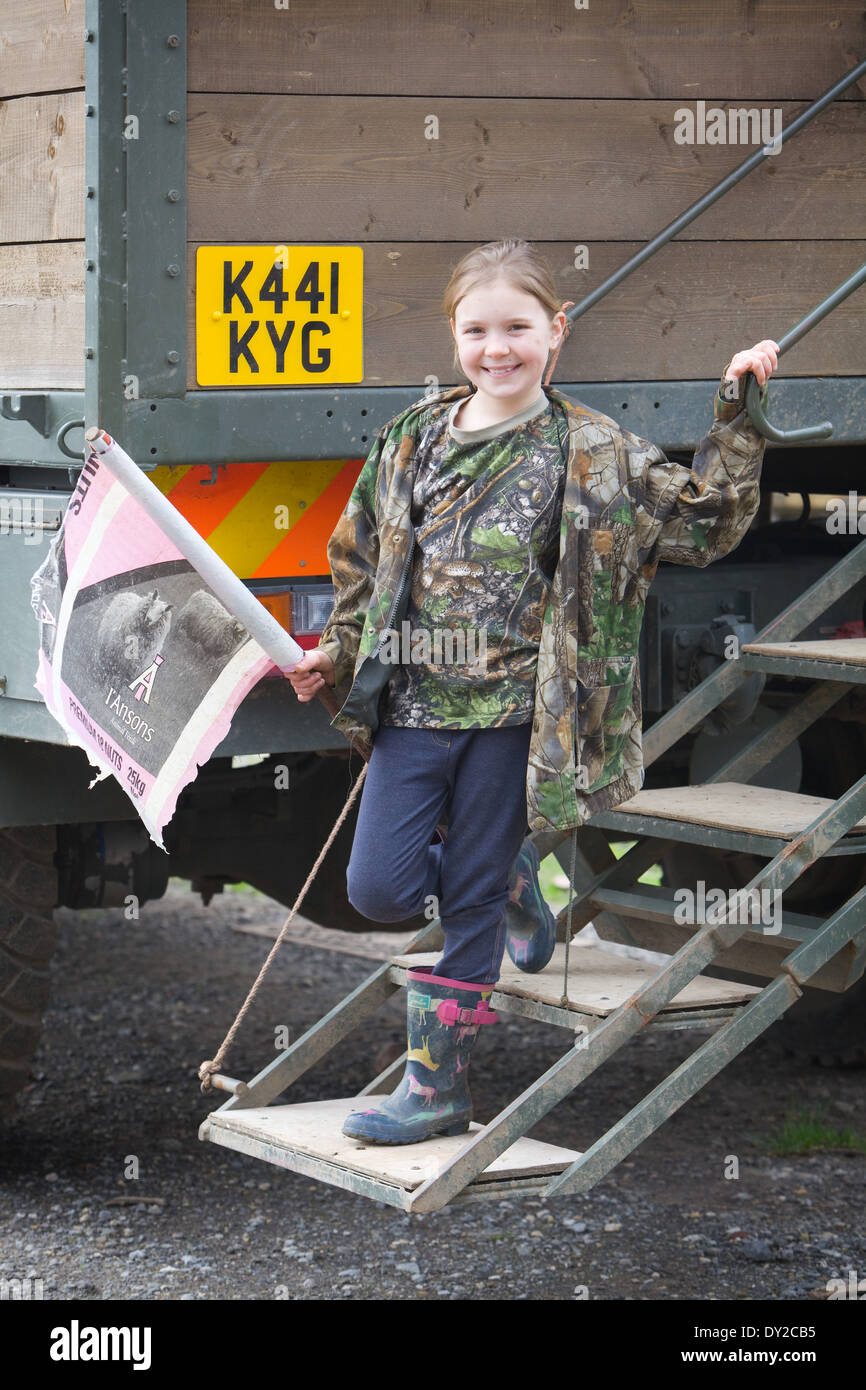Una joven batidor bush sosteniendo una bandera hecha en casa mientras está de pie en la parte trasera de un camión de varillas o pistolas en un rodaje Foto de stock