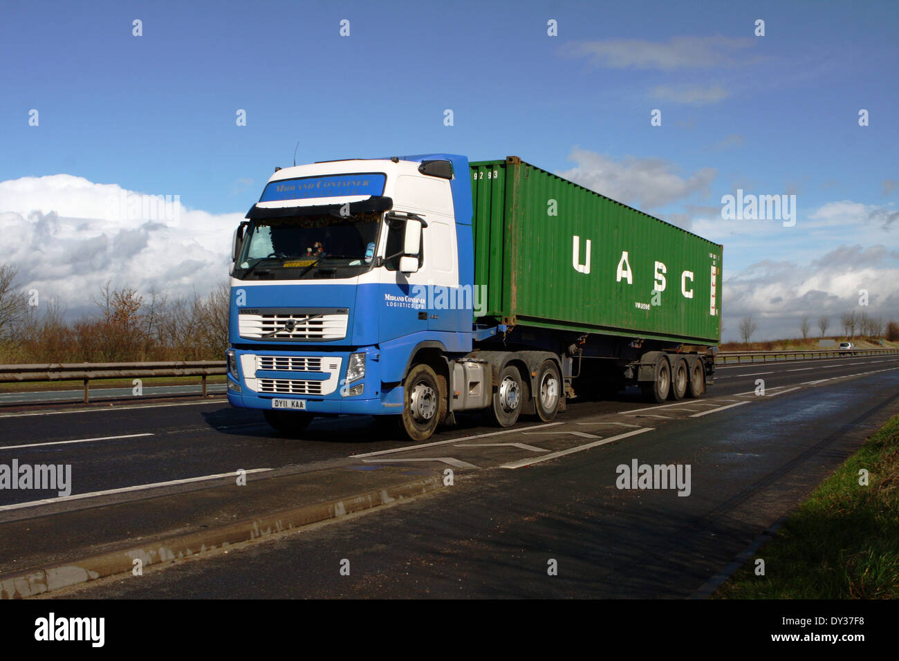 Un Midland Logística de Contenedores camión que transporta un contenedor de envío árabe unida a lo largo de la autovía A46 en Inglaterra. Foto de stock