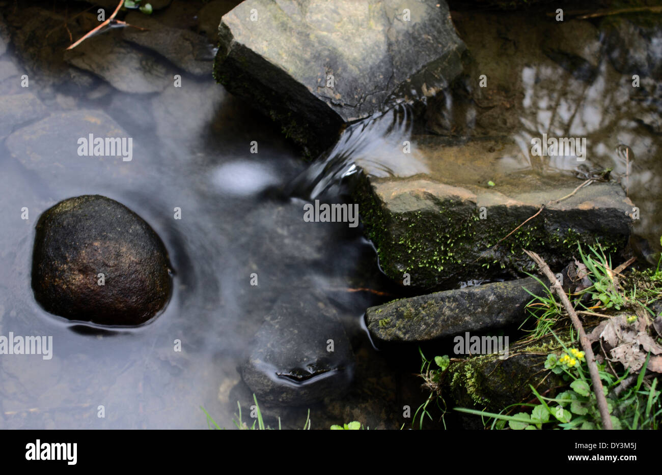 De cerca una suave caída de agua que rodean una roca Foto de stock