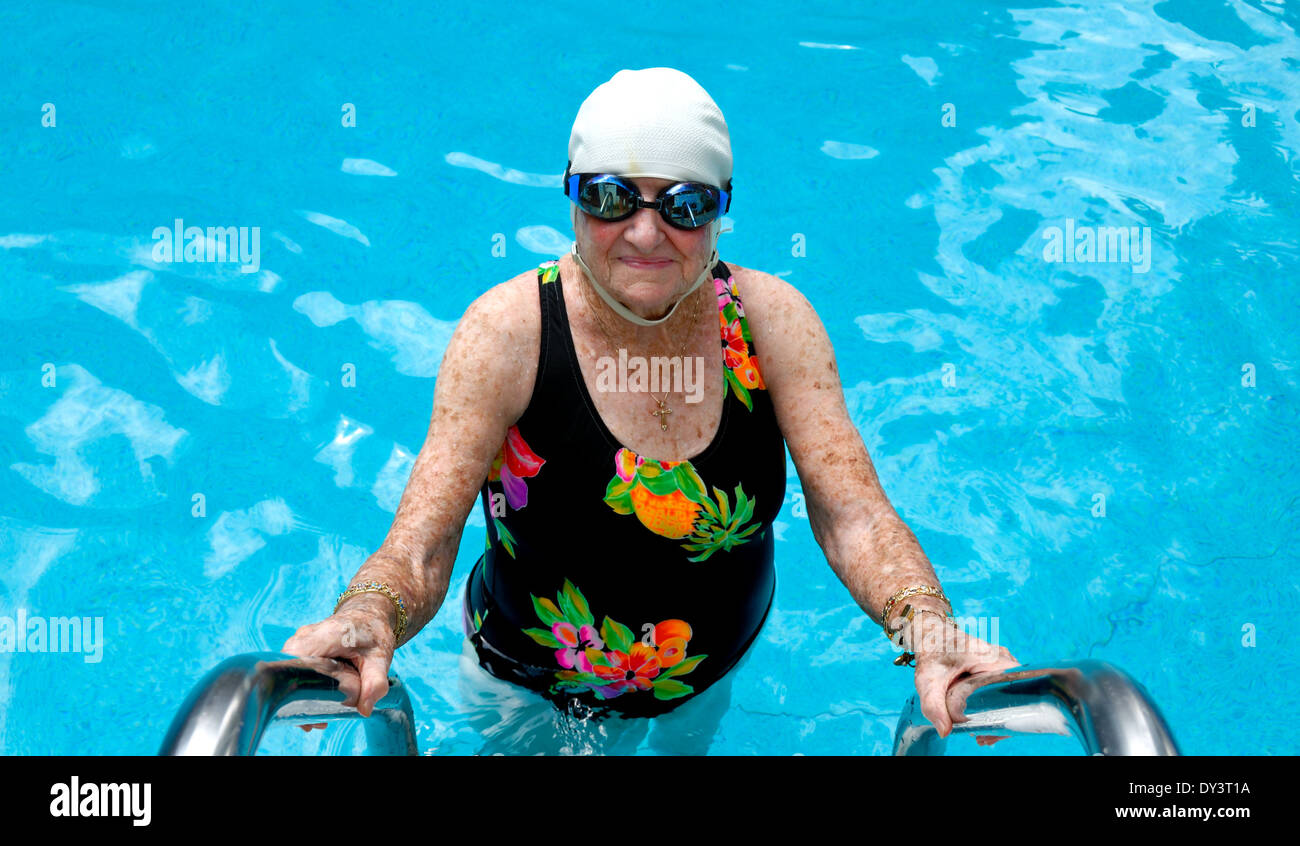 Una mujer senior citizen en traje de baño, gorra y gafas natación
