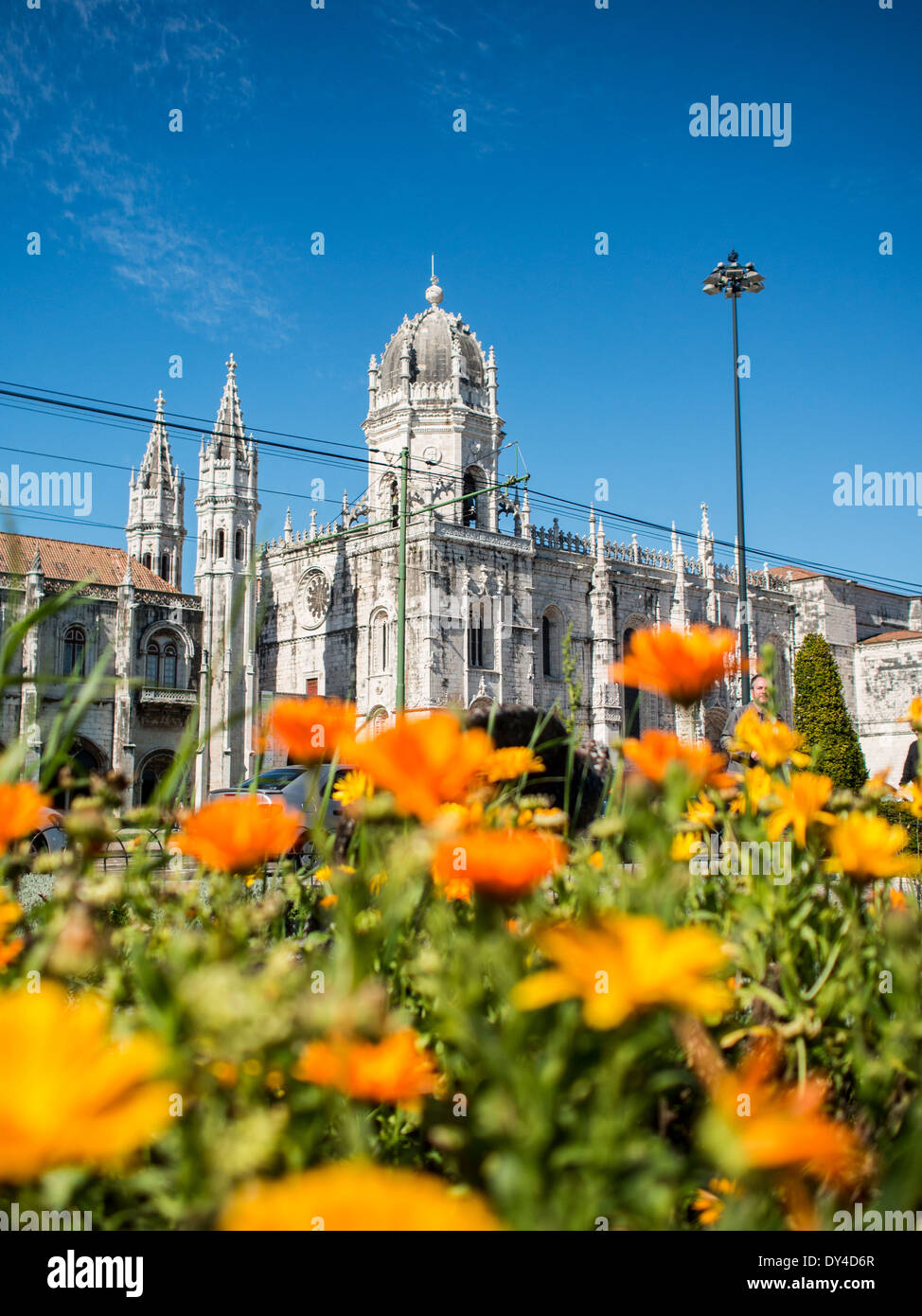 El Monasterio de los Jerónimos con flores anaranjadas en primer plano Foto de stock