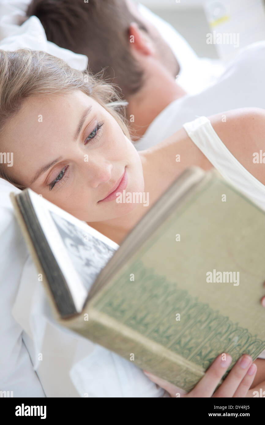 Mujer leyendo en la cama Foto de stock
