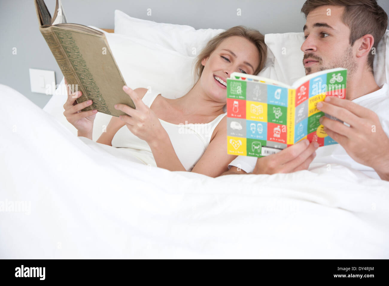 Pareja en la cama leyendo Foto de stock