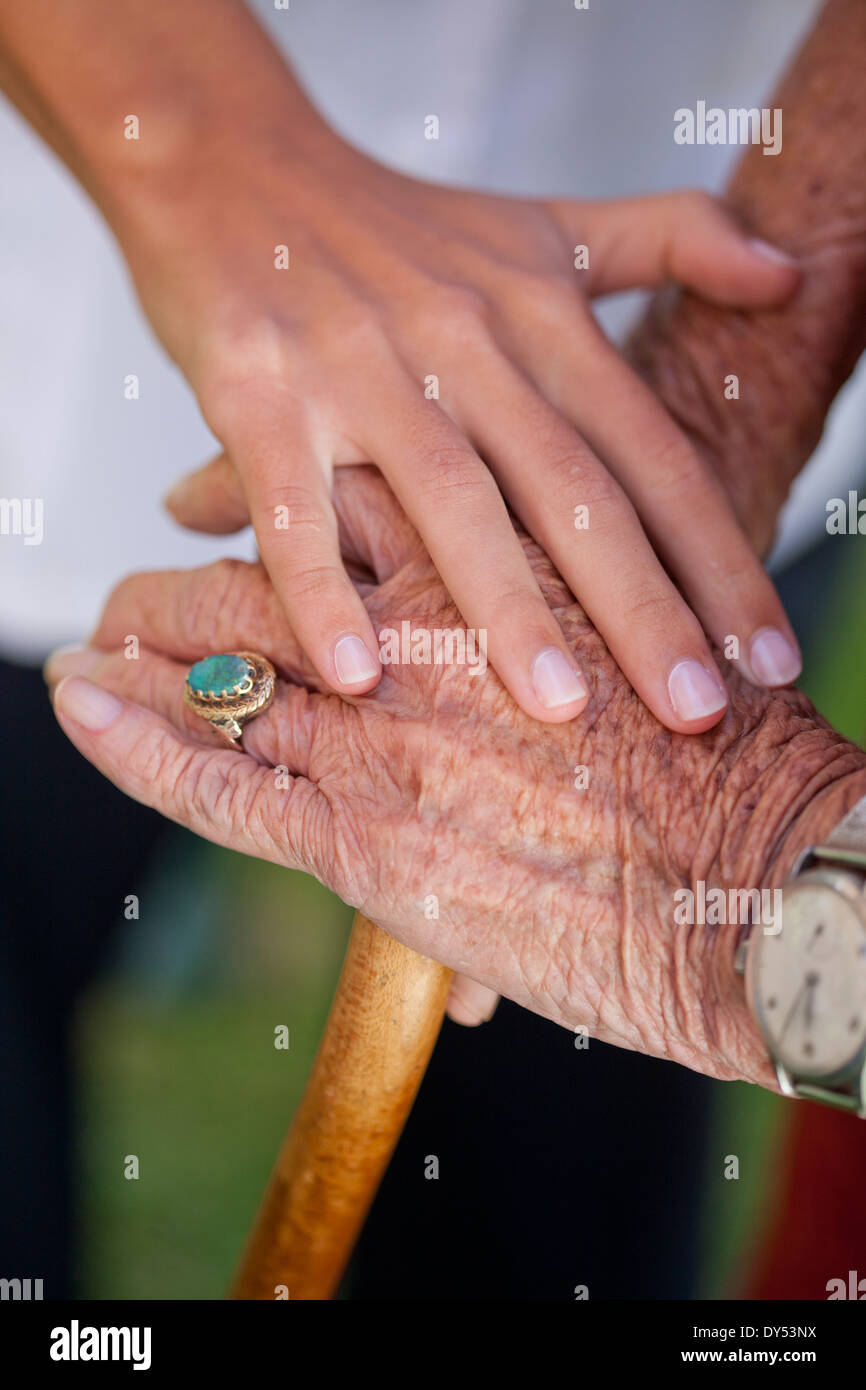 Cerca de asistentes de atención reconfortante Mano mujer senior Foto de stock