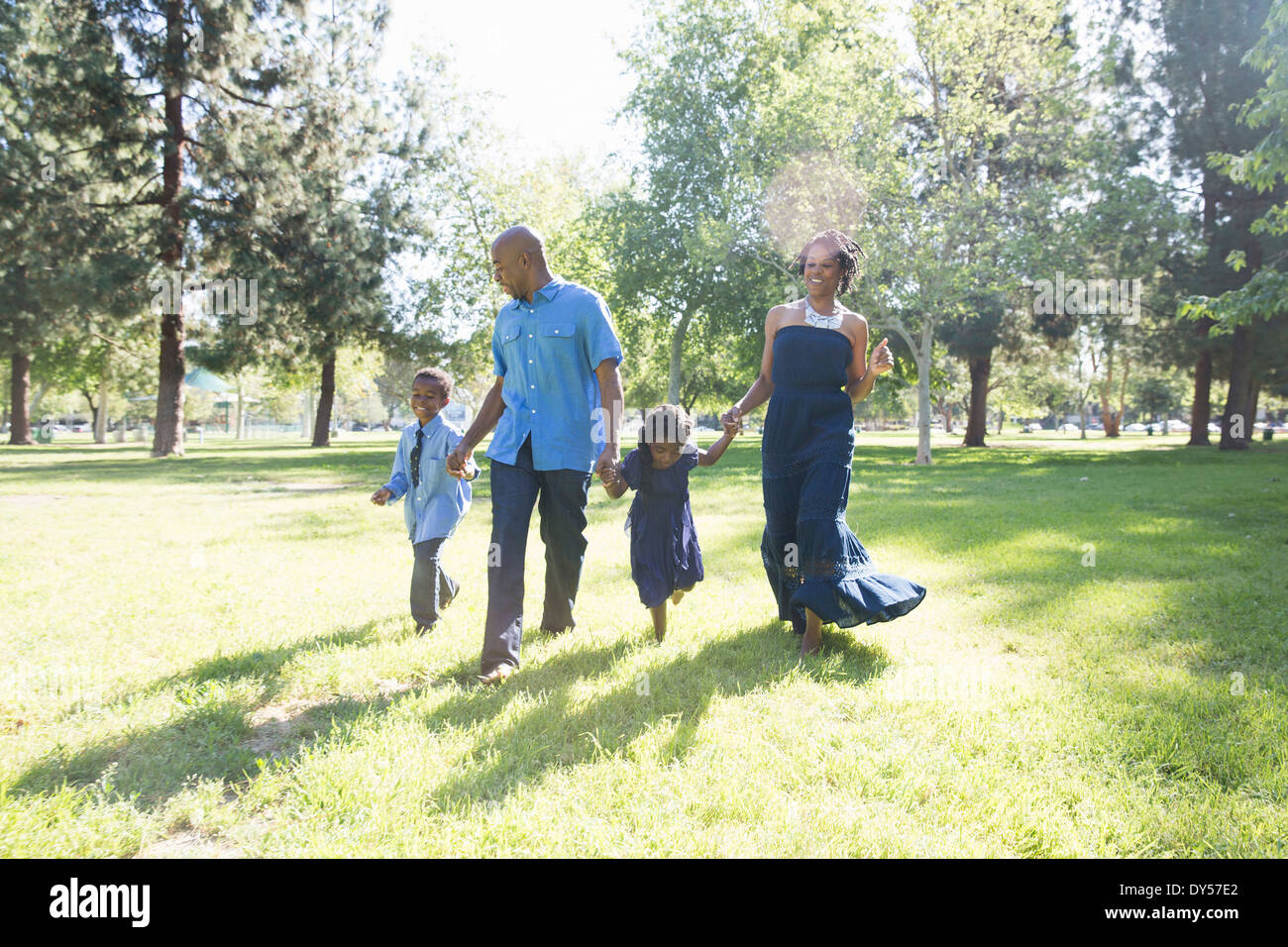 Pareja con hijo e hija paseando en el parque Foto de stock