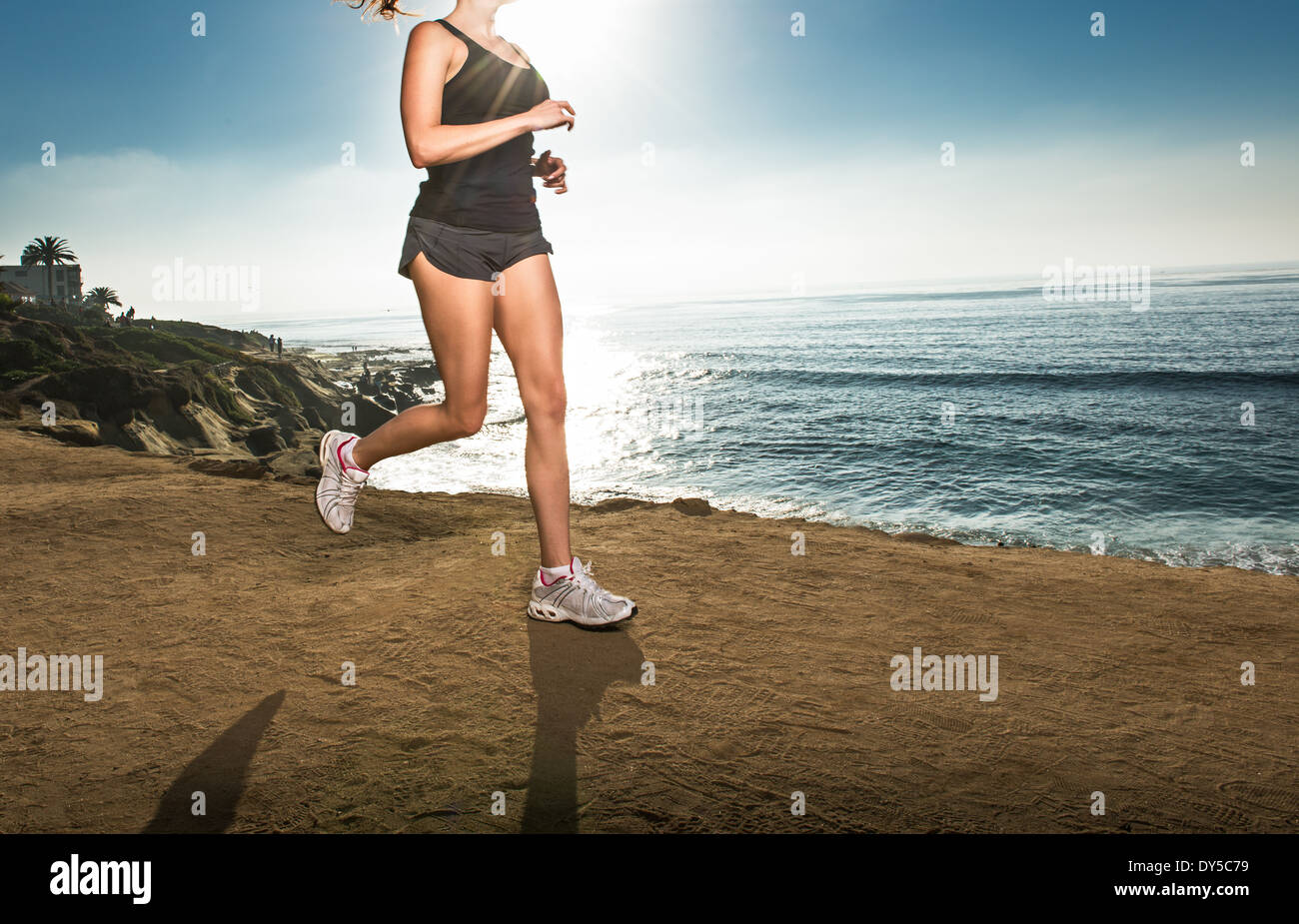 Mujer adulta media jogging en acantilado Foto de stock