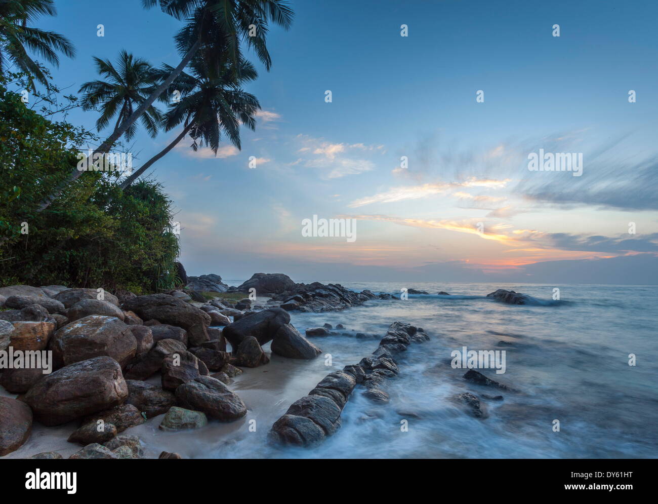 Amanecer en una apartada laguna con rocas y palmeras enmarcan la vista, Tangalle, Sri Lanka, el Océano Índico, Asia Foto de stock