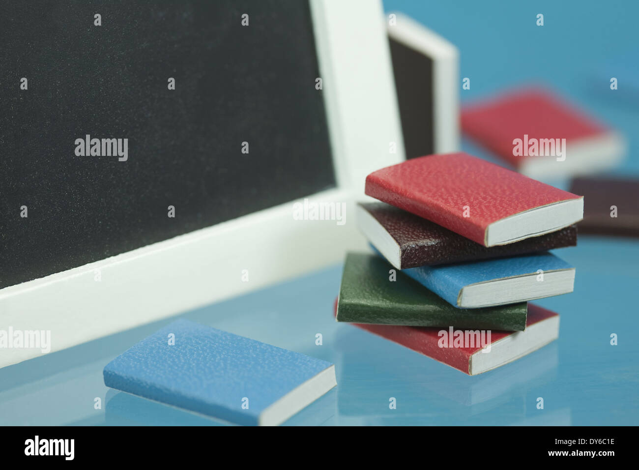 Concepto de regreso a la escuela con los libros escolares en miniatura y blackboard Foto de stock