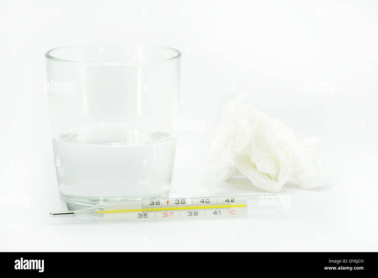 Termómetro cerca de una taza de agua con aspirina y pañuelo Foto de stock