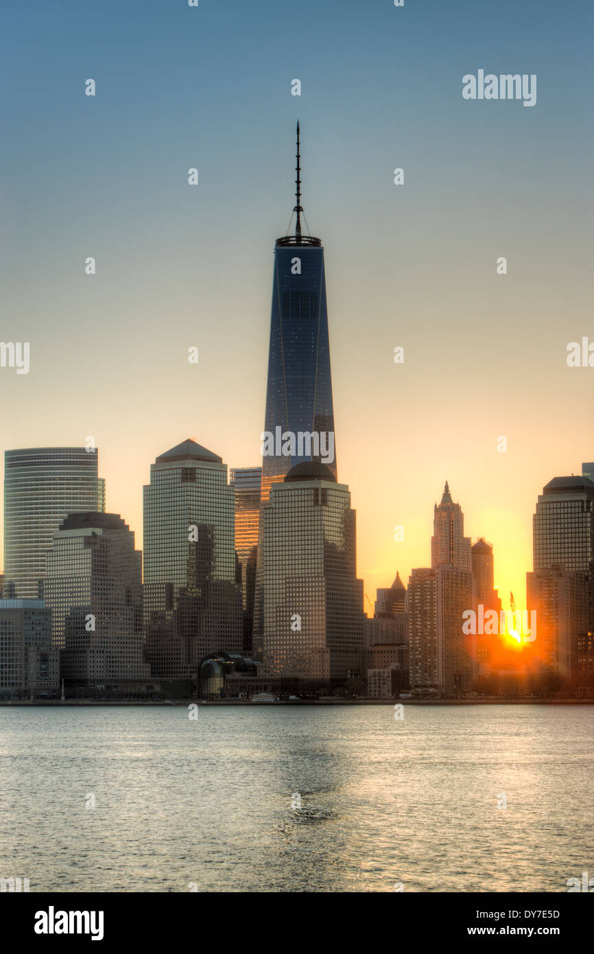 El sol se levanta sobre la parte inferior de Manhattan y la Torre de la Libertad (1 World Trade Center) en la Ciudad de Nueva York. Foto de stock