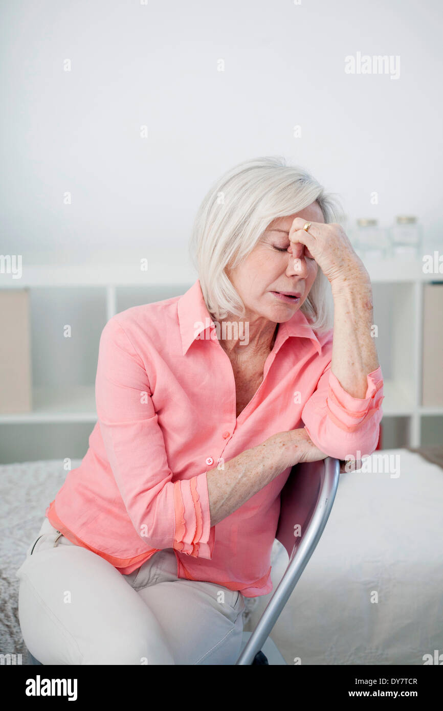 Persona de edad avanzada con dolor de cabeza Foto de stock