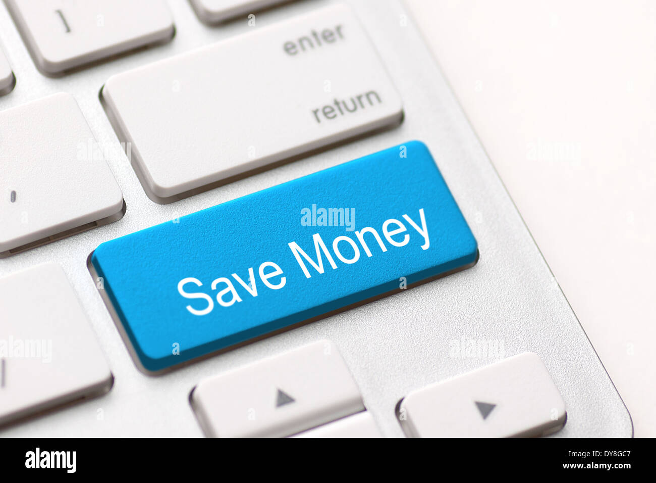 Ahorrar dinero por concepto de inversión con un botón azul en el teclado del ordenador Foto de stock