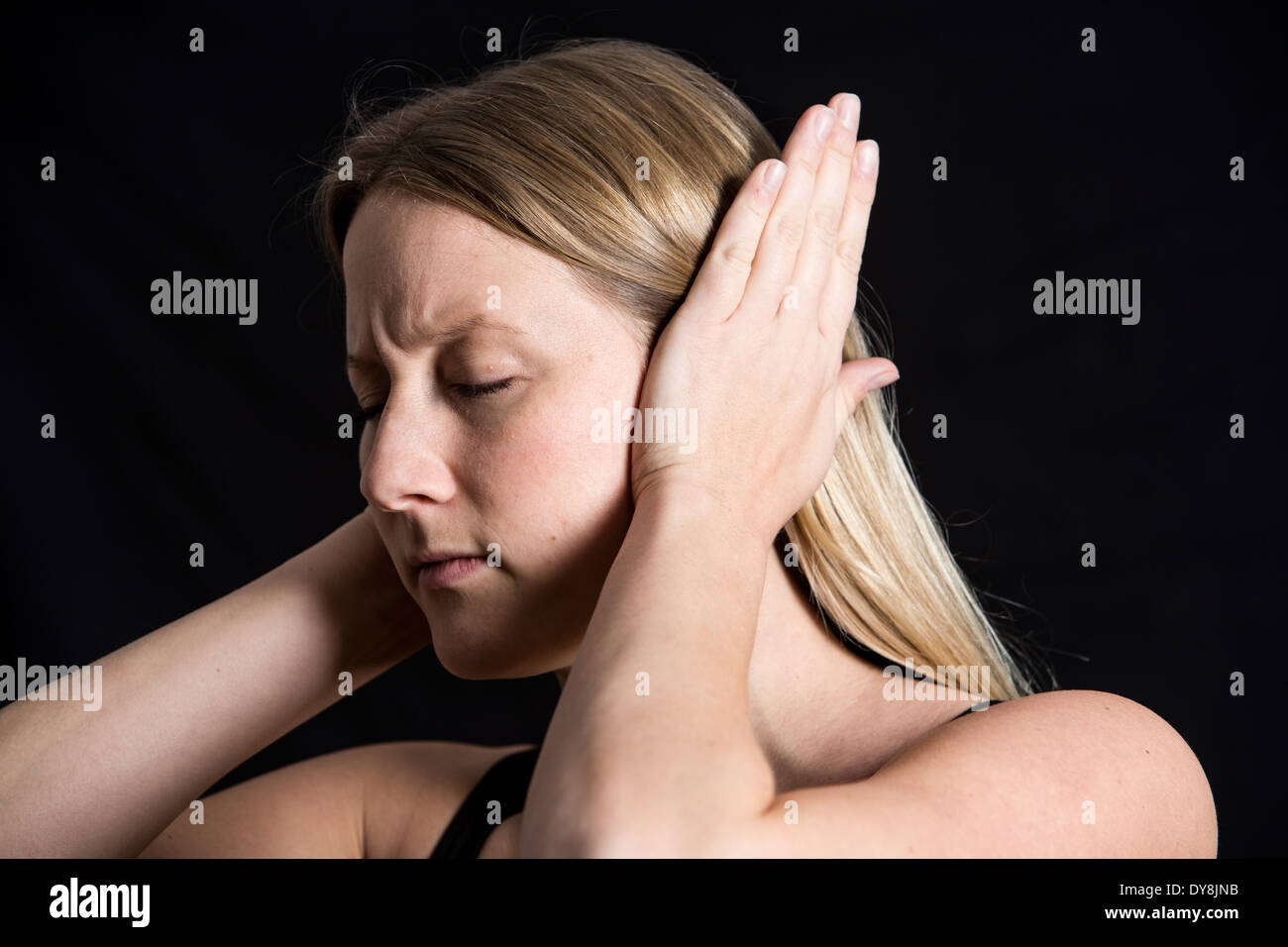 Mujer joven tiene un dolor de oído, Foto de stock
