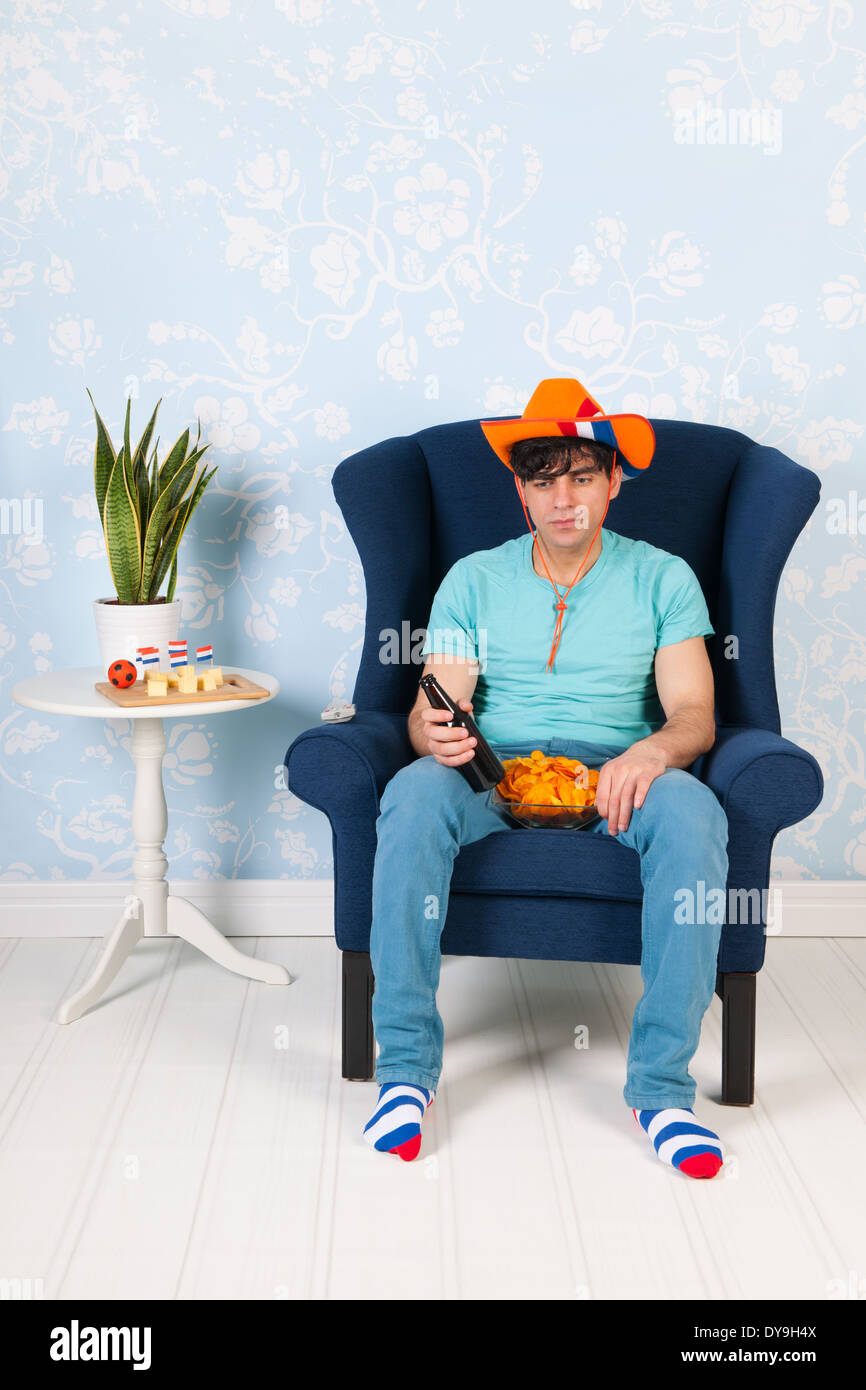 El hombre en la vida mirando televisión como simpatizante del fútbol holandés Foto de stock