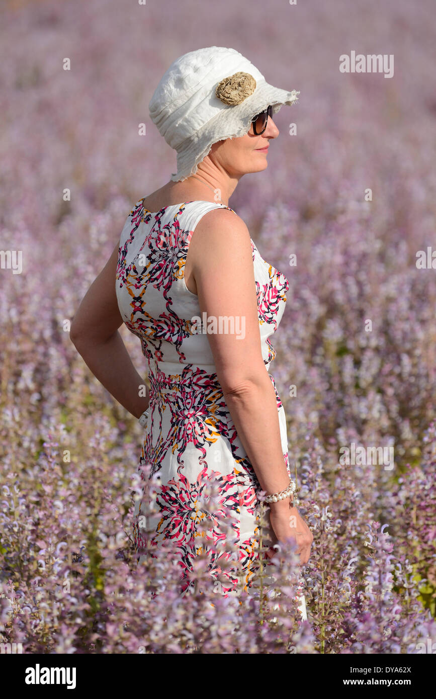 Francia Provenza paisaje mujer flores florecen verano francés a pie hat VINTAGE DRESS liberado valensole campo vertical Foto de stock