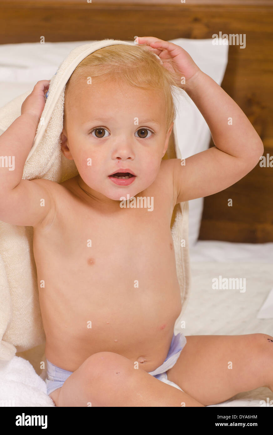 Niño jugando peek-a-boo después del baño en la cama Fotografía de stock -  Alamy