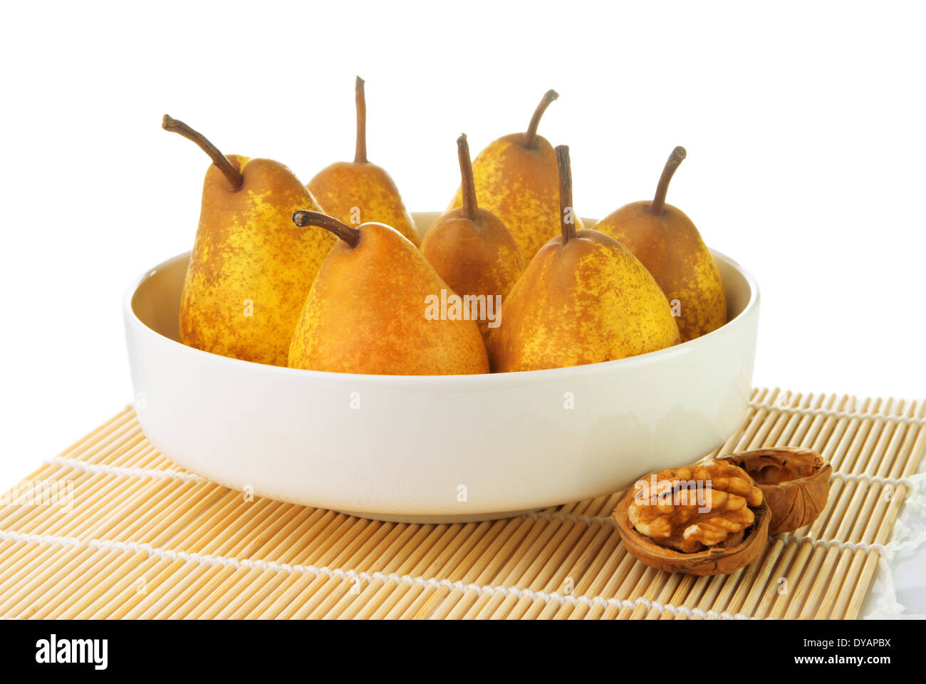 Peras maduras amarillo blanco en un recipiente con una nuez Foto de stock