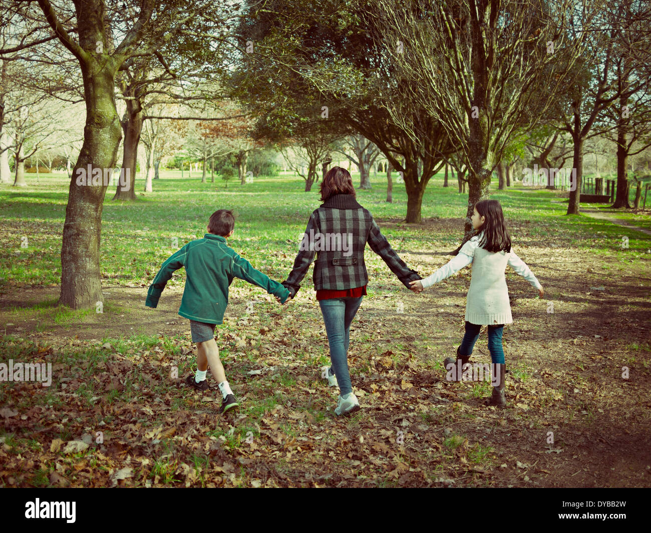 Madre, hijo e hija caminar en el parque. Foto de stock