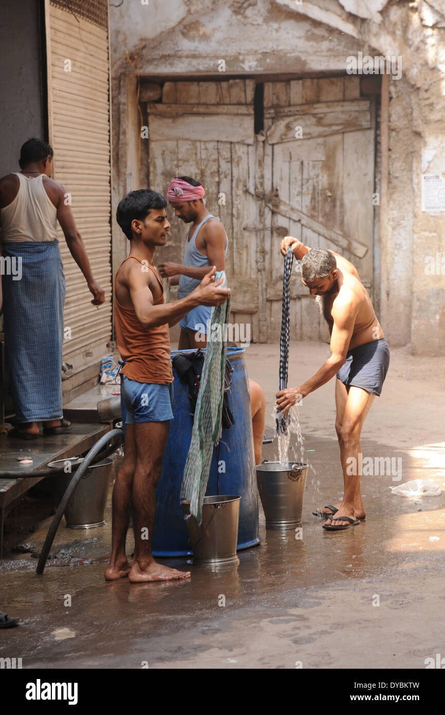 Nueva Delhi, India. El 6 de abril de 2014. Los hombres lavando su ropa en la ciudad de Vieja Delhi, India. Foto de stock