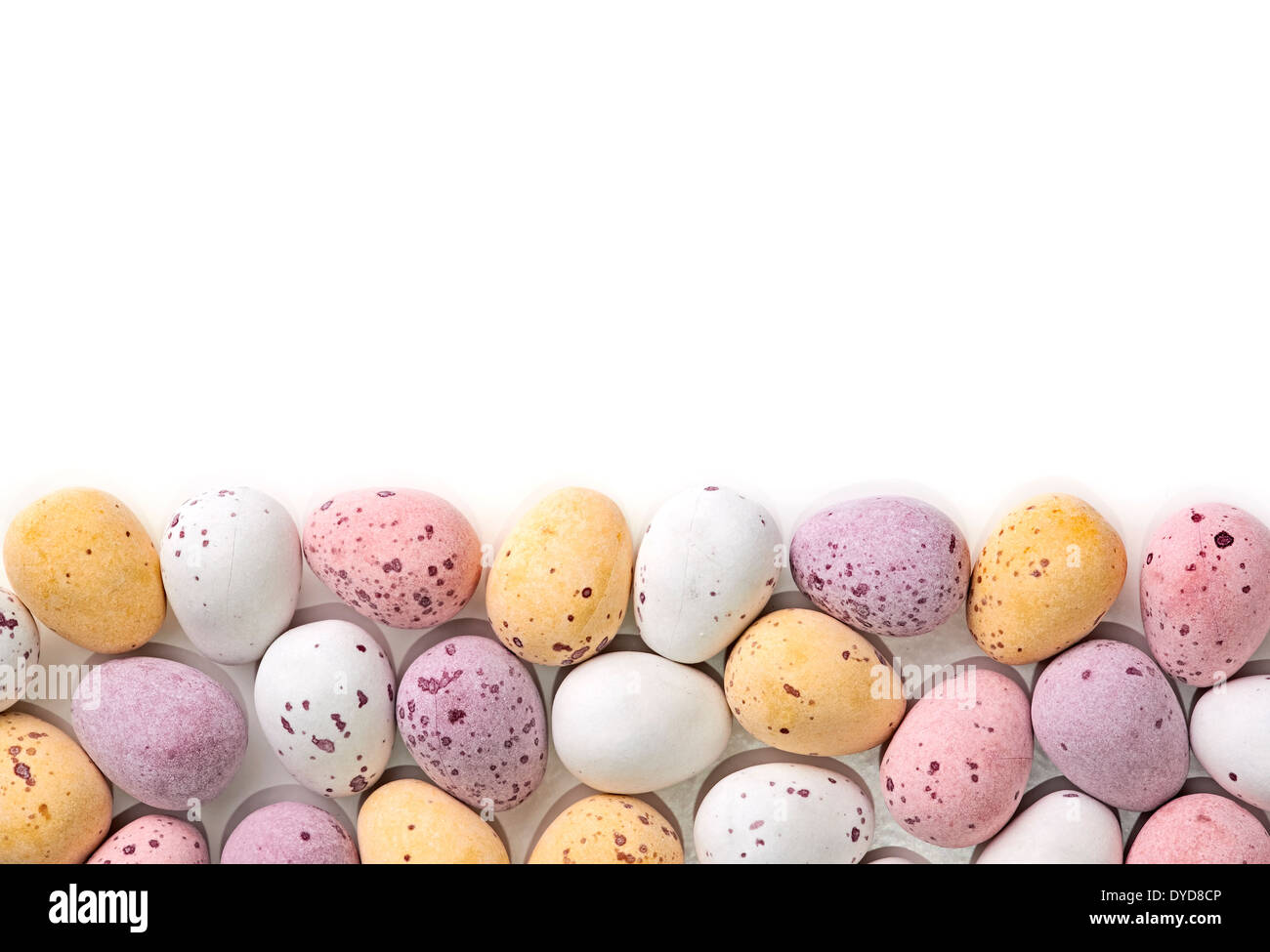 Una selección de huevos de Pascua de chocolate con un caramelo crujiente de shell sobre un fondo blanco. Foto de stock