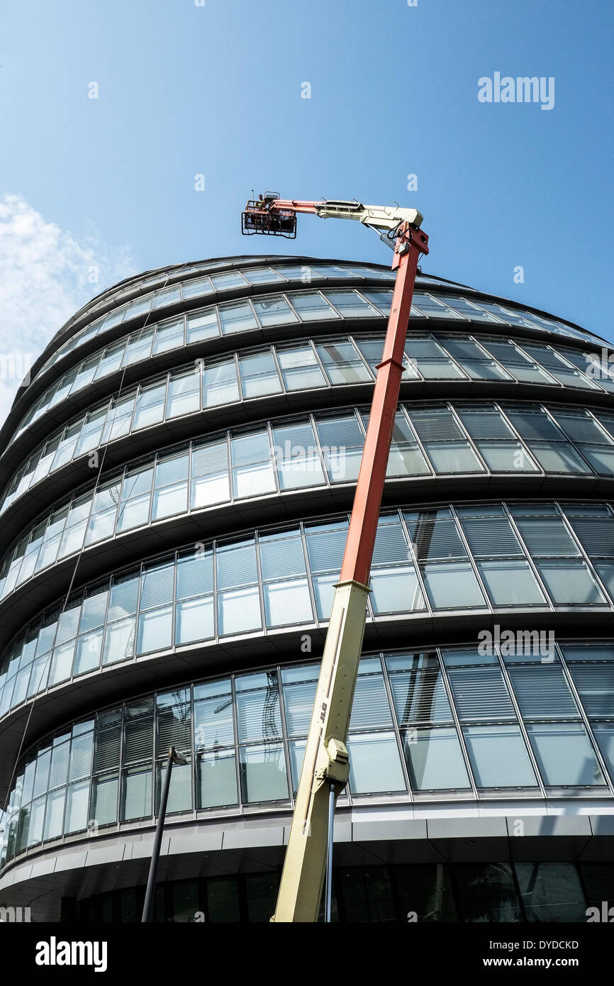 Los trabajadores con una muy buena cabeza para alturas de prepararse para llevar a cabo el mantenimiento de las ventanas de la London City Hall. Foto de stock