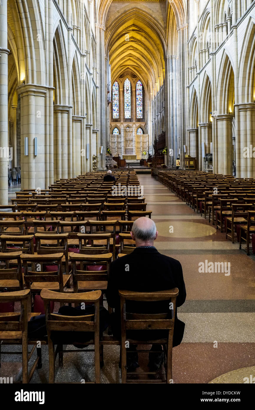 Un hombre sentado tranquilamente en Truro Catedral. Foto de stock