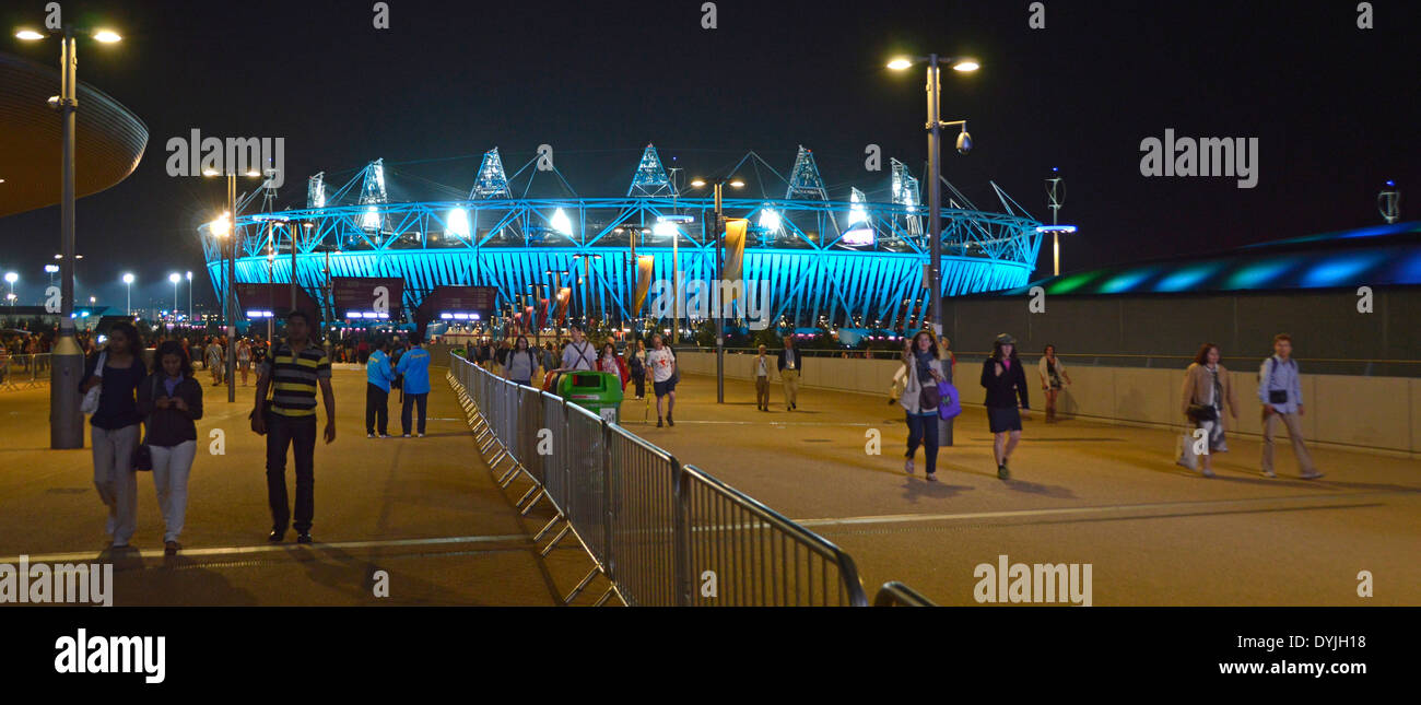 Los espectadores de las Olimpiadas caminan desde el este de Londres 2012 Juegos Paralímpicos iluminados Evento nocturno iluminación Estadio Olímpico Stratford Newham Londres Inglaterra Reino Unido Foto de stock