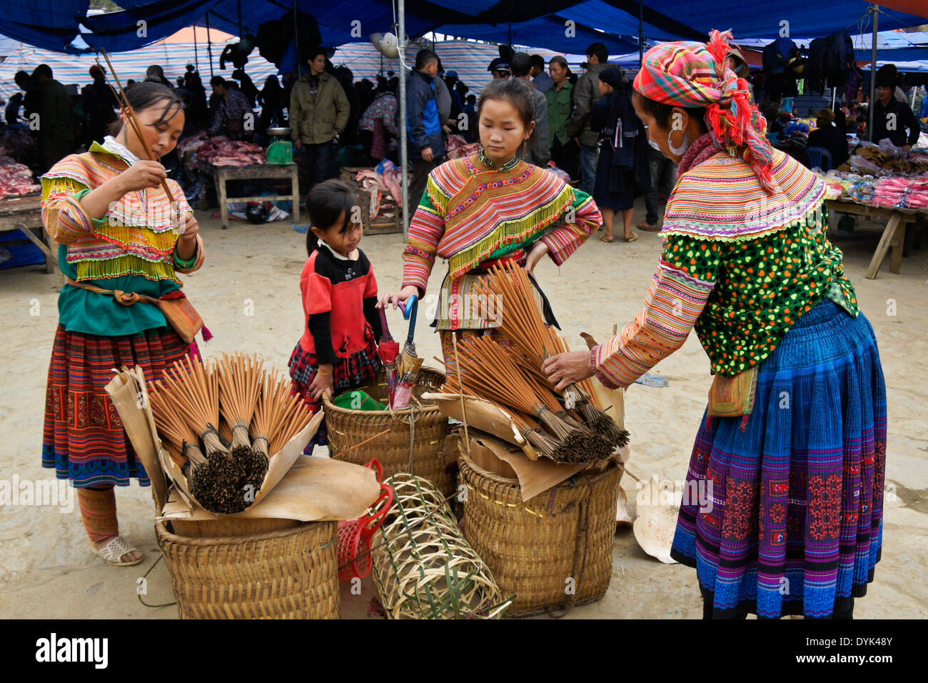 Las mujeres Hmong flor y niños vendiendo incienso en el mercado dominical, Bac Ha, Sapa Sa (Pa), Vietnam del Norte Foto de stock