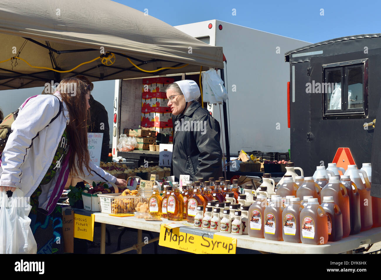 Mennonite mujer vendiendo el jarabe de arce, St. Jacobs Farmers Market, Ontario Foto de stock